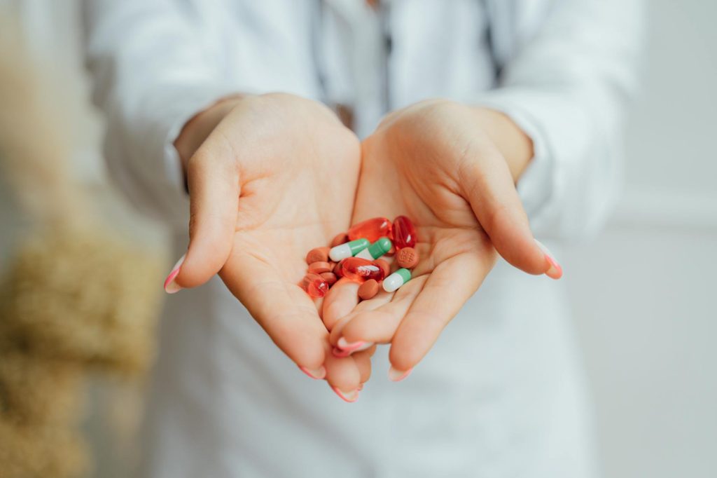 person holding red and green beads
